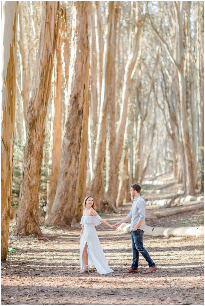 engaged couple walking along lover lane tree path